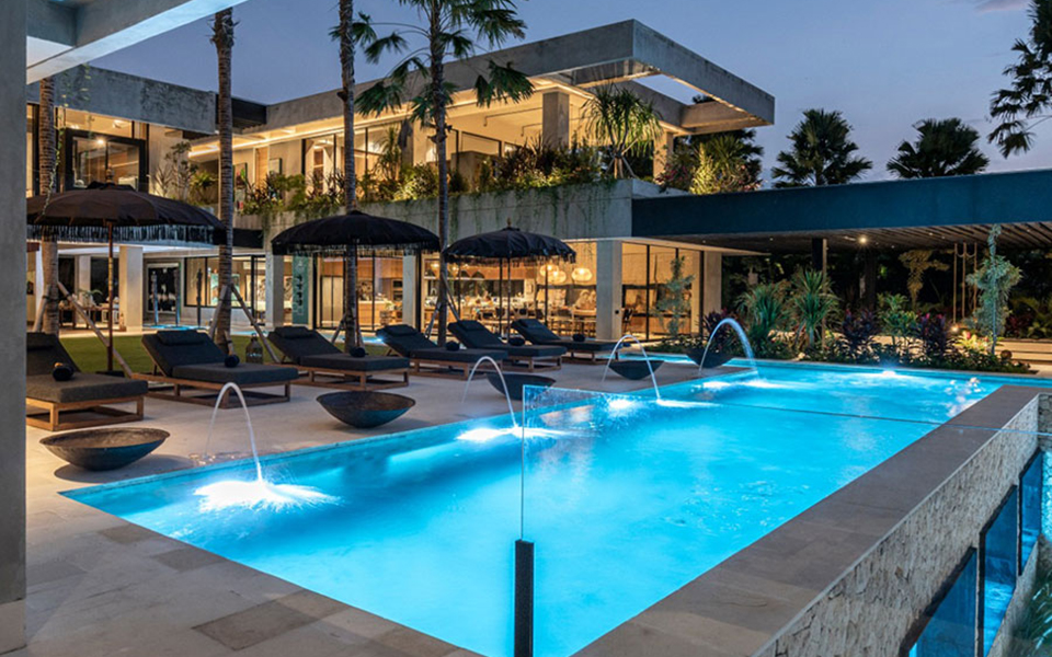 The villa and pool illuminated at dusk